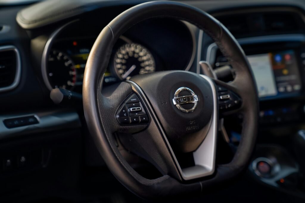 Detailed view of a Nissan car steering wheel showcasing internal functions and design.