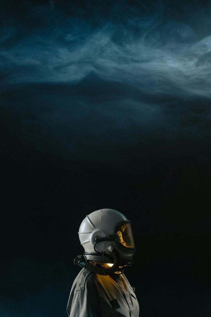 Exploring the unknown, a lone astronaut stands in a smoky and atmospheric dark environment.